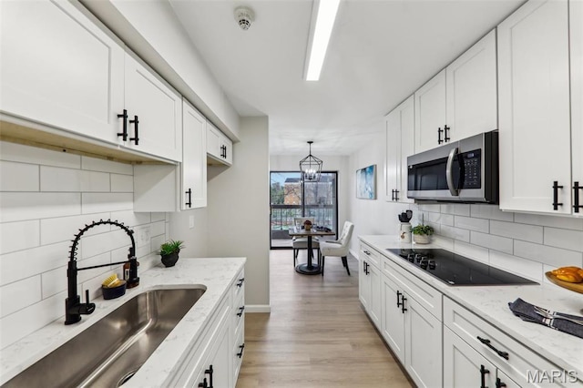 539 Coeur De Royale Dr Unit 201, Saint Louis, MO 63141 - kitchen featuring stainless steel microwave, a sink, white cabinetry, and backsplash