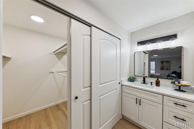 539 Coeur De Royale Dr Unit 201, Saint Louis, MO 63141 - bathroom featuring wood finished floors, vanity, a closet, ensuite bathroom, and baseboards