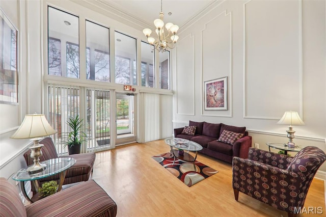 539 Coeur De Royale Dr Unit 201, Saint Louis, MO 63141 - living area featuring a chandelier, wood finished floors, a decorative wall, ornamental molding, and a towering ceiling