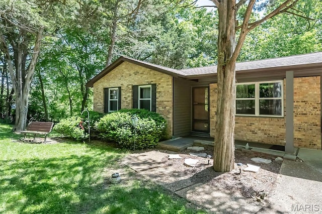 single story home with brick siding and a front yard