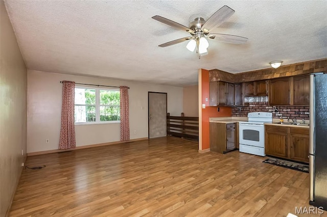kitchen with white electric stove, light wood-style flooring, a textured ceiling, light countertops, and a ceiling fan