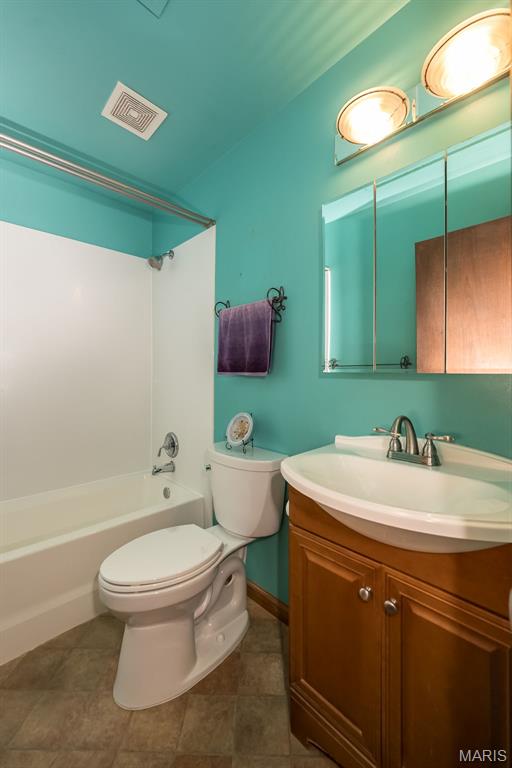 bathroom with toilet, vanity, shower / washtub combination, and tile patterned flooring