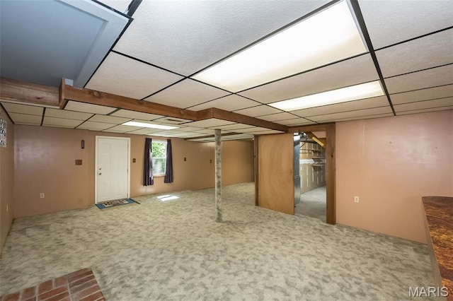 below grade area featuring a paneled ceiling and carpet flooring