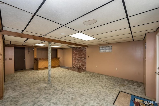 finished basement featuring a drop ceiling and carpet floors