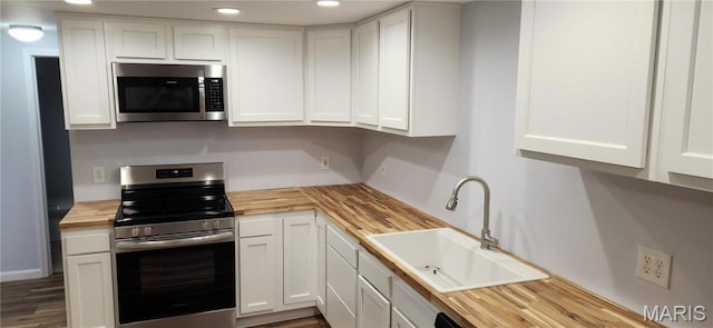 13559 Kitt Park Dr, Saint Genevieve, MO 63670 - kitchen with wood counters, appliances with stainless steel finishes, white cabinetry, recessed lighting, and wood finished floors