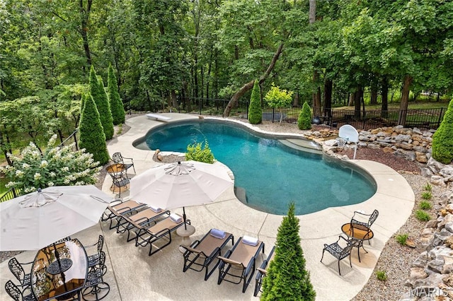 view of swimming pool featuring fence and a patio