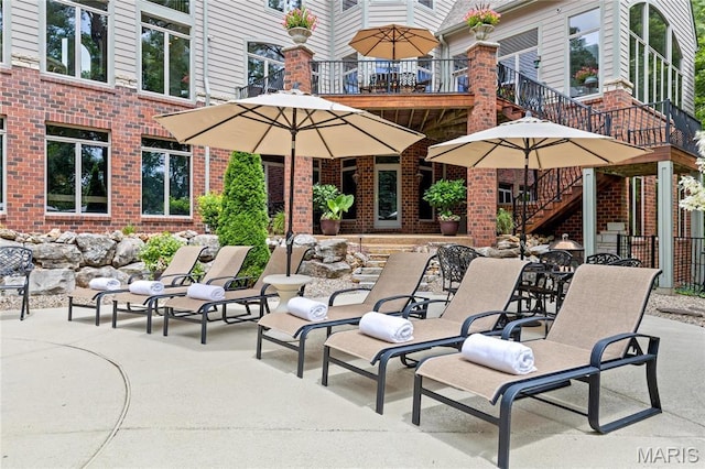view of patio featuring stairway and a balcony
