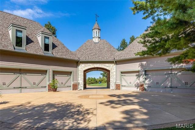 french provincial home with driveway, brick siding, an attached garage, and a shingled roof