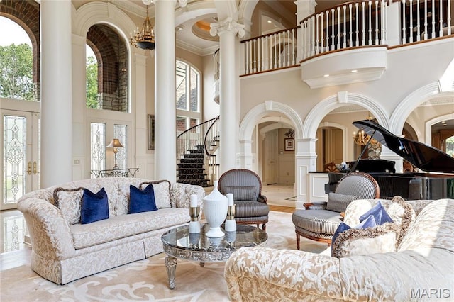 common area with a towering ceiling, ornamental molding, and stairs
