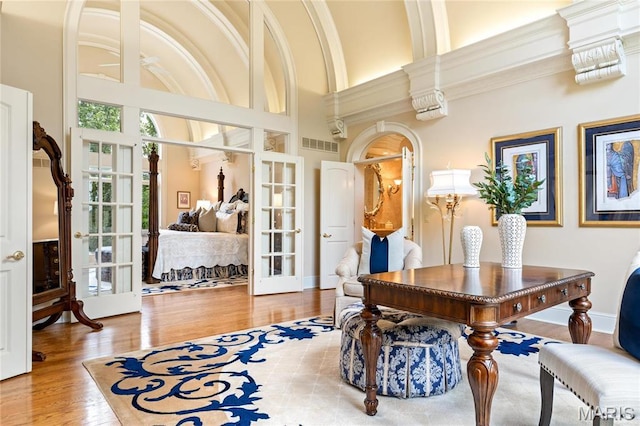 office area with french doors, wood finished floors, and a high ceiling