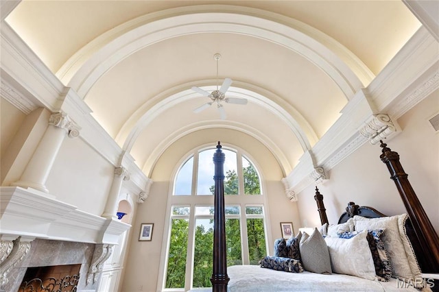 bedroom with high vaulted ceiling, a high end fireplace, and ornate columns