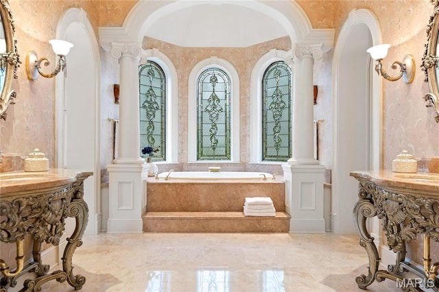 bathroom with a garden tub, a sink, ornate columns, marble tiled flooring, and ornamental molding