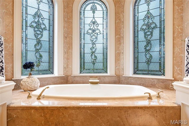 bathroom featuring wallpapered walls and a garden tub