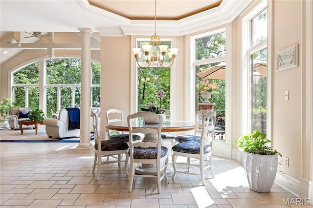 dining space with ornamental molding, plenty of natural light, ornate columns, and a chandelier