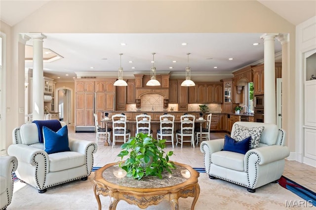 living area featuring ornate columns, vaulted ceiling, crown molding, and recessed lighting