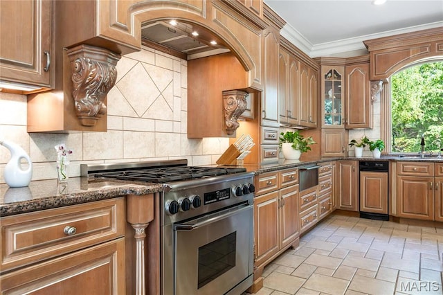 kitchen featuring high end stove, a warming drawer, dark stone counters, crown molding, and a sink