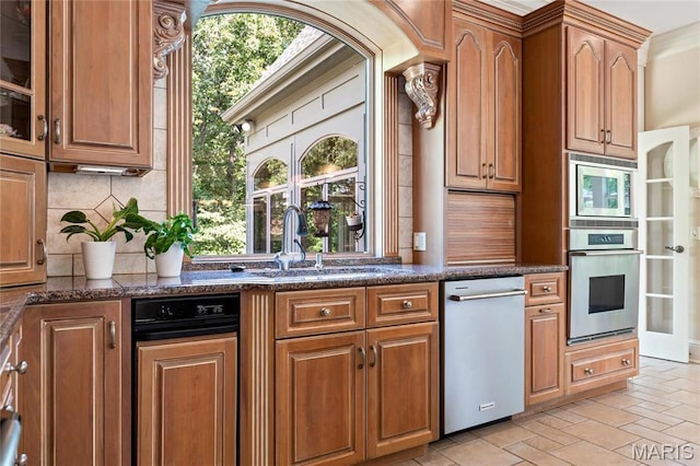 kitchen featuring appliances with stainless steel finishes, a sink, tasteful backsplash, and healthy amount of natural light