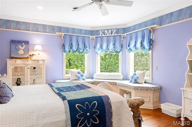 bedroom with multiple windows, wood finished floors, and ceiling fan