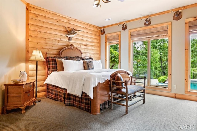 carpeted bedroom with access to outside and multiple windows