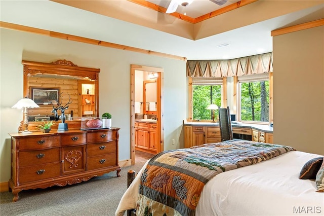 carpeted bedroom with connected bathroom and a sink