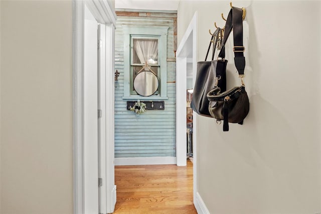 hallway featuring wood finished floors and baseboards