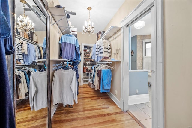 walk in closet featuring a chandelier and wood finished floors