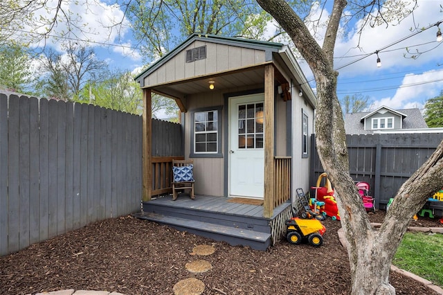 view of outbuilding with a fenced backyard and an outbuilding