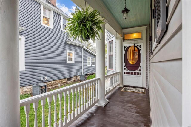 property entrance with central air condition unit, a porch, and a chimney