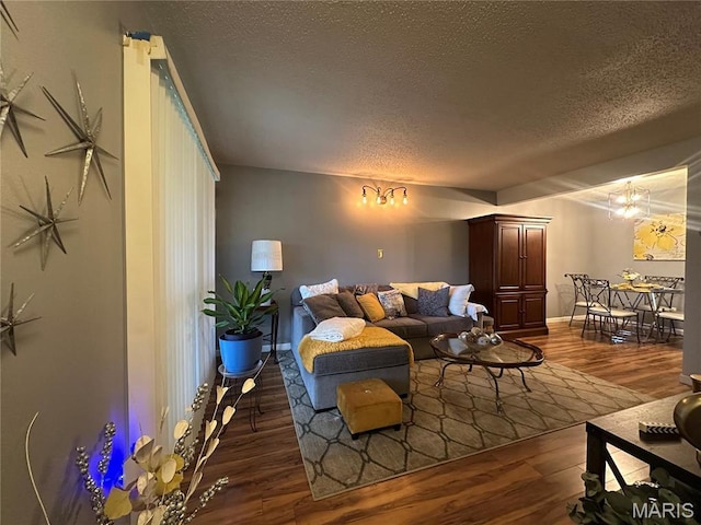 living area featuring a textured ceiling, wood finished floors, and baseboards