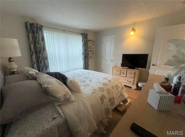 bedroom with light wood-style flooring and a textured ceiling