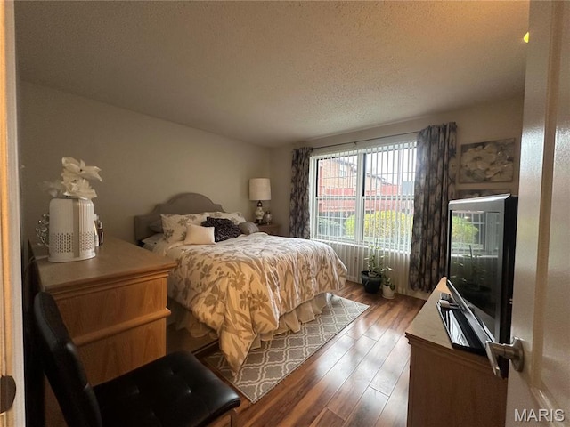 bedroom featuring wood finished floors and a textured ceiling