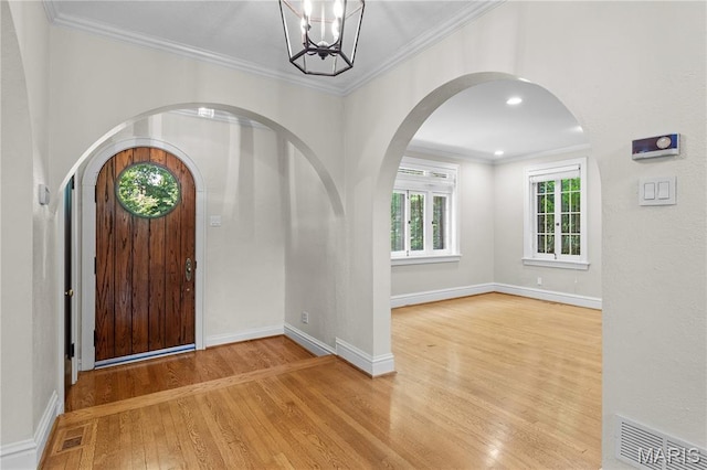 46 Broadview Dr, Clayton, MO 63105 - foyer entrance with wood finished floors, arched walkways, a chandelier, crown molding, and recessed lighting