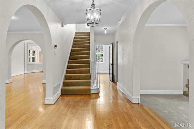 46 Broadview Dr, Clayton, MO 63105 - foyer entrance featuring ornamental molding, light wood-style flooring, stairs, and a chandelier