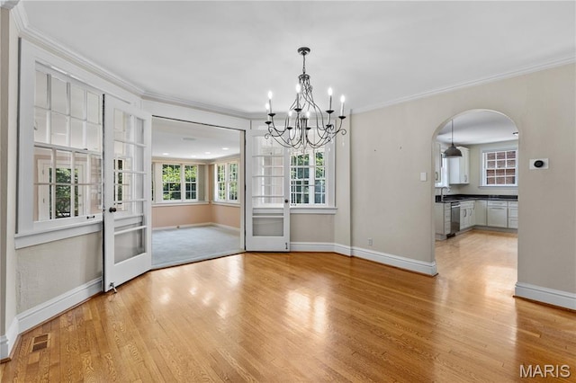 46 Broadview Dr, Clayton, MO 63105 - unfurnished dining area with ornamental molding, light wood-type flooring, a chandelier, and arched walkways