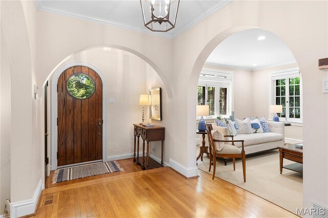 46 Broadview Dr, Clayton, MO 63105 - entryway with arched walkways, wood finished floors, a chandelier, crown molding, and recessed lighting