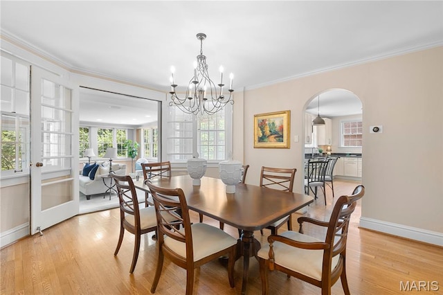 46 Broadview Dr, Clayton, MO 63105 - dining space with a chandelier, crown molding, healthy amount of natural light, light wood-type flooring, and arched walkways