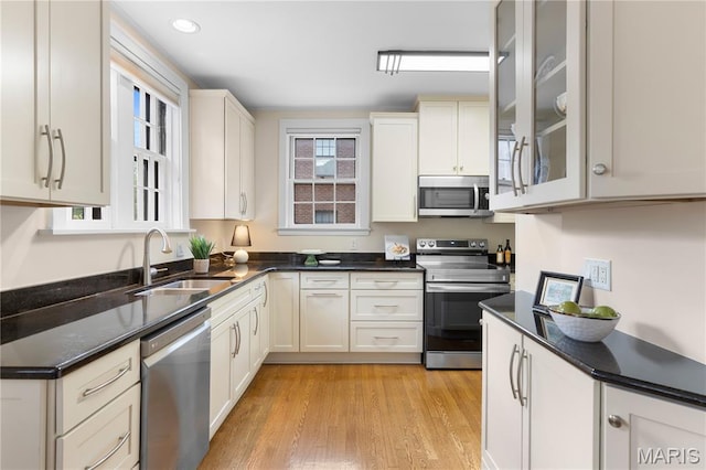 46 Broadview Dr, Clayton, MO 63105 - kitchen featuring stainless steel appliances, light wood-style floors, glass insert cabinets, dark stone counters, and recessed lighting