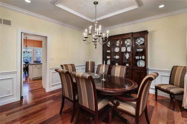 14643 Chermoore Dr, Chesterfield, MO 63017 - dining area featuring a chandelier, a decorative wall, dark wood-style floors, crown molding, and wainscoting