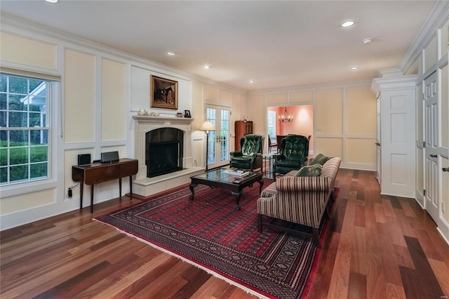 14643 Chermoore Dr, Chesterfield, MO 63017 - living room with a decorative wall, crown molding, wood finished floors, a fireplace with raised hearth, and a chandelier