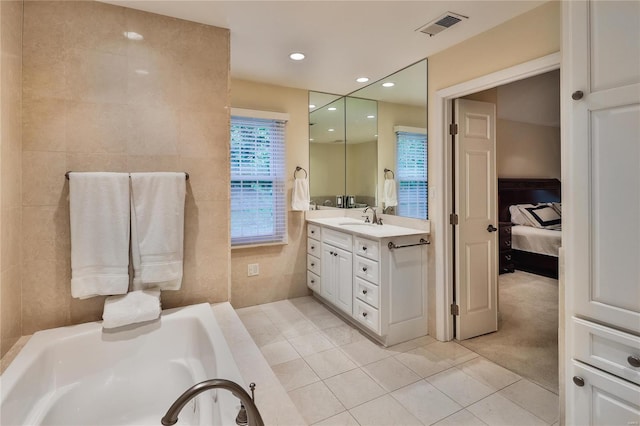 14643 Chermoore Dr, Chesterfield, MO 63017 - ensuite bathroom with tile patterned flooring, tile walls, a bath, vanity, and recessed lighting