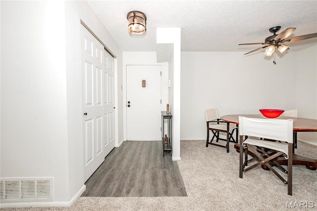 dining area with baseboards, a ceiling fan, a textured ceiling, and wood finished floors