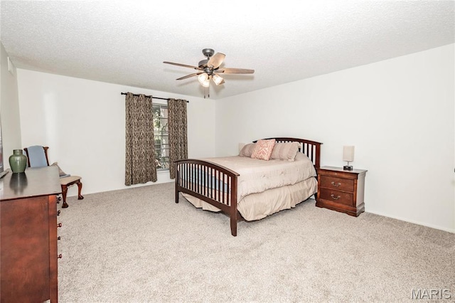 bedroom featuring light carpet, a ceiling fan, and a textured ceiling