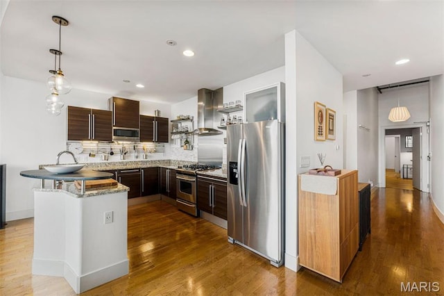 4100 Forest Park Ave Unit 403, Saint Louis, MO 63108 - kitchen featuring appliances with stainless steel finishes, exhaust hood, dark wood-type flooring, backsplash, and recessed lighting