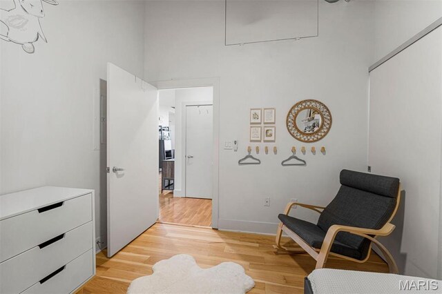 4100 Forest Park Ave Unit 403, Saint Louis, MO 63108 - sitting room featuring light wood finished floors, attic access, a high ceiling, and baseboards