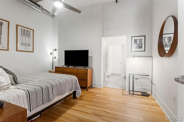 4100 Forest Park Ave Unit 403, Saint Louis, MO 63108 - bedroom with light wood finished floors, a high ceiling, baseboards, connected bathroom, and a ceiling fan