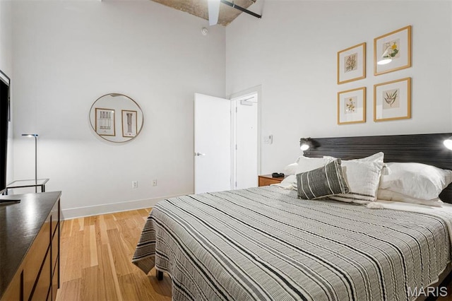 4100 Forest Park Ave Unit 403, Saint Louis, MO 63108 - bedroom featuring light wood-type flooring, a towering ceiling, and baseboards