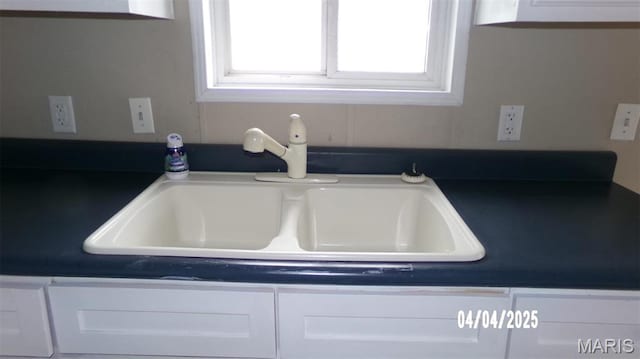 610 E Green St, Mascoutah, IL 62258 - kitchen view of a sink, dark countertops, and white cabinets