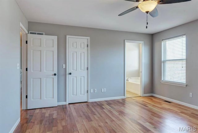 911 Valse Ct, Lake St Louis, MO 63367 - unfurnished bedroom featuring wood finished floors, baseboards, connected bathroom, ceiling fan, and a closet