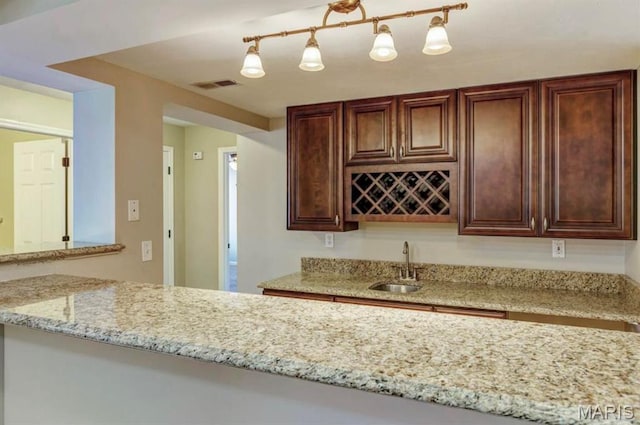 911 Valse Ct, Lake St Louis, MO 63367 - kitchen featuring a sink, light stone counters, and dark brown cabinetry