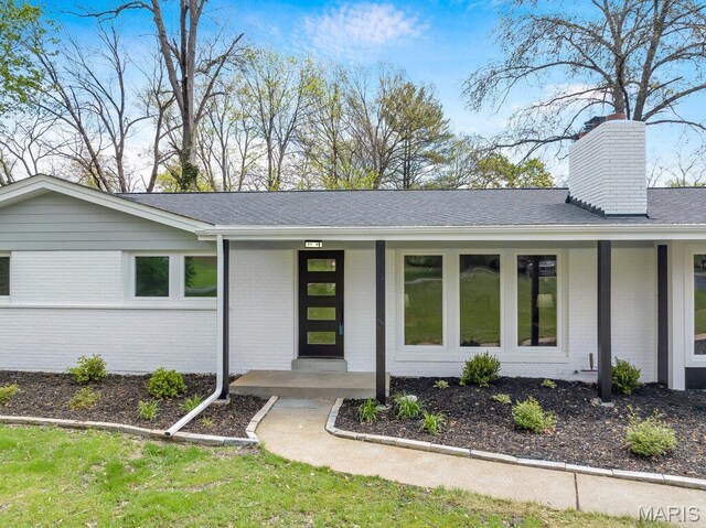 6 Cedar Crst, Saint Louis, MO 63132 - view of front facade with brick siding, a porch, a chimney, and roof with shingles